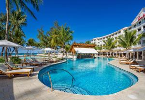 基督教堂市Sandals Barbados All Inclusive - Couples Only的度假村的游泳池,配有椅子和遮阳伞