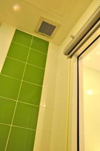 坤敬此地旅馆的浴室设有绿色的墙壁和淋浴