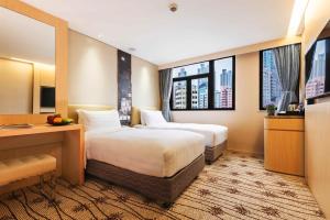 香港旺角维景酒店的酒店客房配有两张床和一张书桌