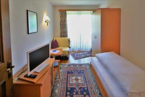 圣沃尔夫冈西雀瓦伯酒店的酒店客房,配有床和电视