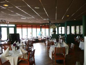 霍勒姆Kaapshoff 32的一间设有白色桌椅和窗户的用餐室