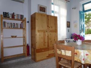 哈尔基岛Halki Townhouse的一间带桌子和木柜的用餐室