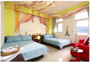 礁溪宏来民宿 的一间卧室配有两张床和一张红色沙发