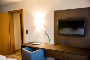 索梅拉伽斯特苏微本拉姆酒店的一间酒店客房,墙上设有一张桌子和一台电视