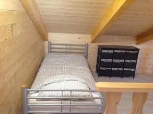 维灵厄韦夫Hollands Oostenrijks huisje的小屋内的一张小床,拥有木制天花板