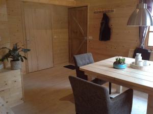 维灵厄韦夫Hollands Oostenrijks huisje的一间带木桌和椅子的用餐室