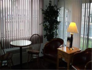 科尔特斯Cozy Inn的客厅配有桌椅和台灯