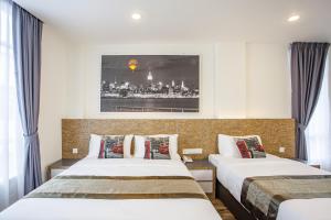 努沙再也自然酒店 的酒店客房设有两张床,墙上挂着一张照片。