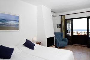圣乔治Can Carlos Ibiza的卧室配有白色的床和蓝色椅子