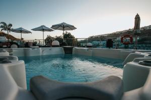 波多黎各Servatur Casablanca Suites & Spa - Adults Only的一个带椅子和遮阳伞的游泳池