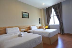 怡保杜塔利亚公寓式酒店的酒店客房设有两张床和窗户。