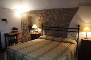 马利亚诺因托斯卡纳Case Cordovani的一间卧室设有一张床和石墙