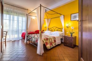 佛罗伦萨安帝卡莫尼耶B&B酒店的一间卧室设有天蓬床和黄色的墙壁。