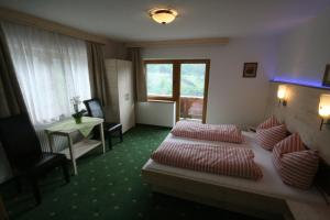 格尔洛斯贝格"Adamerhof"的配有床、椅子和桌子的酒店客房
