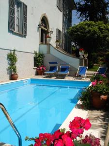 多马索Villa Annamaria B&B的一座房子前带椅子和鲜花的游泳池
