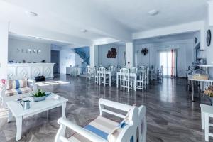 卡马利塞利尼酒店的一间带白色椅子的客厅和一间餐厅