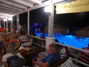 蒂加基蓝巢酒店的一群人坐在带游泳池的餐厅里