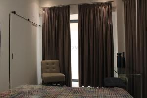 塞图巴尔Day Off Suite&Hostel的卧室配有床、椅子和窗户。