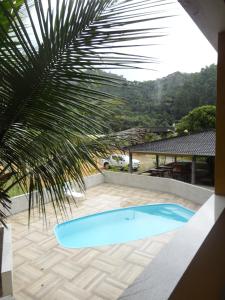 Santa MariaPousada Terra Nossa的享有棕榈树游泳池的景色