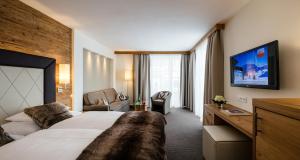 上陶恩Superior Hotel Panorama的酒店客房带一张大床和一把椅子