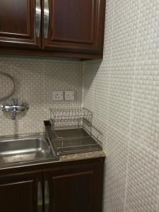 科威特雷德托尔精装公寓的一间带水槽和瓷砖墙的厨房
