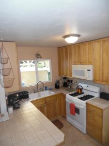 Kehena科合纳海滩度假屋的厨房配有木制橱柜和白色炉灶烤箱。