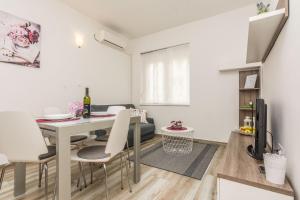 扎达尔Melita Center Apartment的厨房以及带桌椅的起居室。