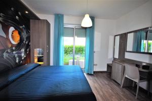 皮内托米拉马雷酒店的一间卧室配有蓝色的床和电视