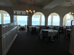 丹尼斯港The Three Seasons Resort的用餐室设有桌椅和窗户。