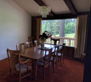 奥克港Wildwood Farm Bed & Breakfast的一间带桌椅和大窗户的用餐室