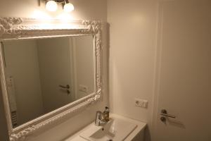 胡萨维克Laxhús的白色的浴室设有镜子和水槽