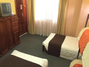 ZamoraHotel Betania的一间酒店客房,设有两张床和电视