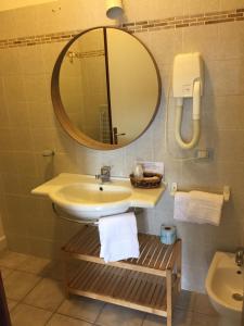 阿尔比尼娅帕尔梅酒店的一间带水槽、镜子和卫生间的浴室