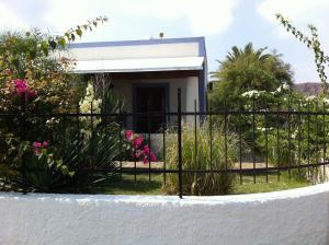 弗卡诺Hotel Rojas的粉红色花朵房子前面的围栏