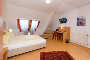 尤登堡斯驰维尔特尔布劳城市酒店的一间卧室配有一张床、一张桌子和一把椅子