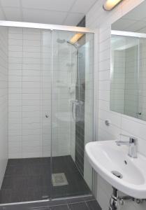 安德内斯Thon Partner Hotel Andrikken的一间带玻璃淋浴和水槽的浴室