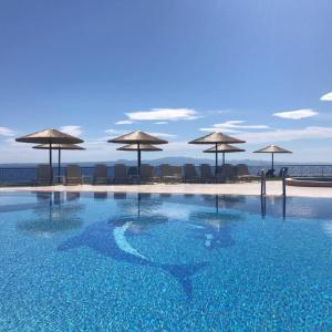 阿菲托斯Aegean Blue Studios CHILDREN OVER 12的海滩上的带遮阳伞的游泳池