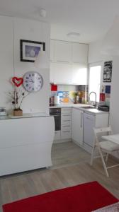 贝尔格莱德乔凡纳科伦斯卡公寓的厨房配有白色橱柜和红色地毯