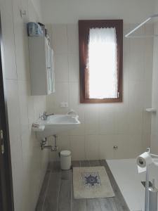 罗切特Agriturismo S. Agostino的一间带水槽和卫生间的浴室以及窗户。