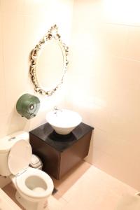 新竹新竹月圆Motel 的一间带卫生间、水槽和镜子的浴室