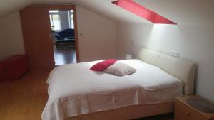 菲拉赫城市奉献公寓的卧室配有白色的床和红色枕头