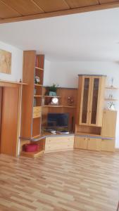 菲拉赫城市奉献公寓的客厅配有木制橱柜和电视。