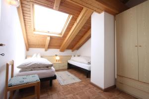 卡瓦莱塞Agritur Chelodi的阁楼卧室设有两张床和窗户。