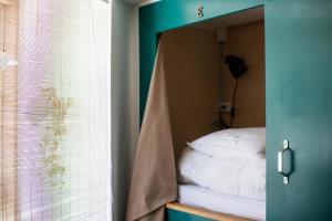 哥本哈根Woodah Hostel的镜子中的一张镜子中的床