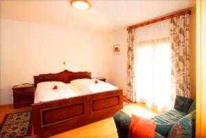 马尔泰洛阿尔培罗赛住宅酒店的一间卧室配有一张床、一张沙发和一个窗口
