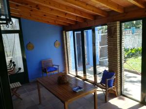 奇克拉纳－德拉弗龙特拉Chalet con piscina privada, natural y acogedor的客房设有木桌和一些窗户。
