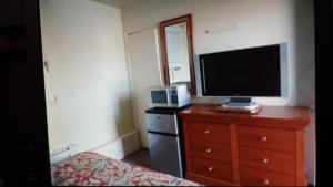 尼亚加拉瀑布艾利威特鲁姆斯星星汽车旅馆的一间卧室配有电视和一个带电视的梳妆台。