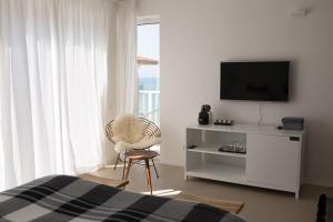 索佐波尔Sea Sense Boutique Hotel & Wellness的一间卧室配有电视、椅子和床