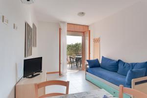 丽都阿德里亚诺Aparthotel Costa Paradiso的客厅配有蓝色的沙发和电视