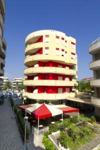 阿尔巴·阿德里亚蒂卡伊思佩利亚酒店的前面有红白雨伞的建筑